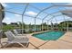A view of the sparkling pool with lounge chairs with lovely landscaping, all within a screened enclosure at 4531 Useppa Dr, Bradenton, FL 34203