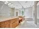 Bright bathroom featuring dual vanities, a large mirror, a soaking tub and glass shower at 4727 Starboard Dr, Bradenton, FL 34208