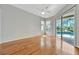 Neutral bedroom with hardwood floors, ceiling fan, and a sliding door with views of the pool area at 4727 Starboard Dr, Bradenton, FL 34208
