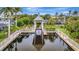 This is a view of a dock with a boat lift, set against a backdrop of tropical greenery at 4727 Starboard Dr, Bradenton, FL 34208