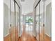 Hallway with hardwood floors and mirrored closet doors leading to a living area with pool views at 4727 Starboard Dr, Bradenton, FL 34208