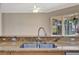 Close up of a kitchen sink, granite countertops, and outlets with a view to the pool and lanai at 4727 Starboard Dr, Bradenton, FL 34208