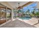 Inviting covered patio with a screen enclosure, overlooking a lush pool and tropical landscape, perfect for relaxation at 4727 Starboard Dr, Bradenton, FL 34208