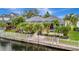 Waterfront home featuring a screened lanai, lush tropical landscaping, and a private dock at 4727 Starboard Dr, Bradenton, FL 34208