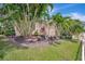 Beautifully landscaped yard featuring tropical plants, lush green lawn and view of the house at 4727 Starboard Dr, Bradenton, FL 34208