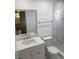 Bright bathroom with white marble tile in the shower and tile floors, vanity with a sink, and a toilet at 481 Saturn Ave, Sarasota, FL 34243