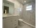 This remodeled bathroom features a large mirror, vanity with sink, toilet, and glass-enclosed marble tile shower at 481 Saturn Ave, Sarasota, FL 34243