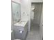 This updated bathroom features a new vanity with sink, mirror, toilet, and modern gray tile floors at 481 Saturn Ave, Sarasota, FL 34243