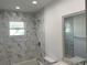 Bathroom featuring marble tiled walls, a shower head and a white toilet at 481 Saturn Ave, Sarasota, FL 34243