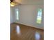 Bright bedroom featuring light, neutral walls, wood floors and two vertical windows overlooking the outdoors at 481 Saturn Ave, Sarasota, FL 34243