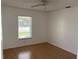 This bright bedroom features wood floors, a ceiling fan, and a window that lets in natural light at 481 Saturn Ave, Sarasota, FL 34243