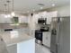 Modern kitchen featuring stainless steel appliances, white cabinets and marbled floors and backsplash at 481 Saturn Ave, Sarasota, FL 34243