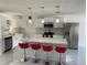 Kitchen features white cabinets, stainless steel appliances, a kitchen island, and barstool seating at 481 Saturn Ave, Sarasota, FL 34243