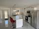 Modern kitchen with stainless steel appliances, white cabinets, marble floors and a breakfast bar with red bar stools at 481 Saturn Ave, Sarasota, FL 34243