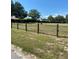 Vacant lot with a wooden fence and green grass under a blue sky at 481 Saturn Ave, Sarasota, FL 34243