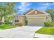 Beautiful front yard with green grass, mature trees, and vibrant flowerbeds enhancing this home's curb appeal at 5005 Torrey Pines Run, Bradenton, FL 34211