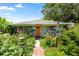 Charming home featuring an orange door and vibrant garden, a welcoming entrance at 5317 14Th S Ave, Gulfport, FL 33707