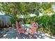 Charming patio area with a unique table and chairs set, shaded by lush trees and greenery for relaxing outdoors at 5317 14Th S Ave, Gulfport, FL 33707