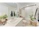 Stylish bathroom with modern vanity, decorative plant, and shower-tub combination at 5711 Archipelago St, Nokomis, FL 34275
