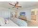 Bright bedroom with a ceiling fan, a TV, and an attached bathroom, perfect for relaxation at 5711 Archipelago St, Nokomis, FL 34275