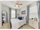 Charming bedroom features blue accents, a full length mirror, and a ceiling fan at 5711 Archipelago St, Nokomis, FL 34275