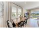 Bright dining room features a wooden table, black chairs, and serene views of the outdoors at 5711 Archipelago St, Nokomis, FL 34275