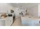 Bright kitchen with white cabinets, stainless steel appliances, and a spacious center island for dining at 5711 Archipelago St, Nokomis, FL 34275