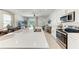 Open kitchen with stainless steel appliances, bright lighting, island seating, and views into the living area at 5711 Archipelago St, Nokomis, FL 34275