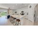 Modern kitchen with an island, bar stool seating, stainless steel appliances, and access to living area at 5711 Archipelago St, Nokomis, FL 34275