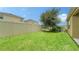 Large backyard features lush greenery, a shade tree, and secure privacy fencing for outdoor enjoyment at 5905 Silver Sage Way, Sarasota, FL 34232