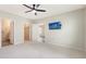 Spacious bedroom that features a ceiling fan, mounted television, and walk-in closet at 5905 Silver Sage Way, Sarasota, FL 34232