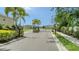 Gated community entrance featuring lush landscaping, palm trees, and a secure entry point at 5905 Silver Sage Way, Sarasota, FL 34232