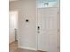 Bright foyer features a six-panel front door with transom window, smart lock, and access to the laundry room at 5905 Silver Sage Way, Sarasota, FL 34232