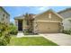 Charming single-Gathering home features a 2-car garage, stone accents, manicured lawn, and a vibrant flowering tree at 5905 Silver Sage Way, Sarasota, FL 34232