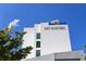 Modern hotel exterior with sleek design, rooftop terrace, and elegant signage against a clear blue sky at 5905 Silver Sage Way, Sarasota, FL 34232