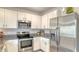 Modern kitchen with white cabinets, stainless steel appliances, granite countertops, and under cabinet lighting at 5905 Silver Sage Way, Sarasota, FL 34232