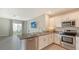 Open concept kitchen features granite countertops, stainless steel appliances and eat-in breakfast bar at 5905 Silver Sage Way, Sarasota, FL 34232