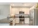 Bright kitchen features granite countertops, stainless steel appliances, white cabinetry, and a stylish faucet at 5905 Silver Sage Way, Sarasota, FL 34232