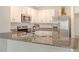 Kitchen with granite countertops, stainless steel appliances, bright white cabinets and a stylish sink at 5905 Silver Sage Way, Sarasota, FL 34232