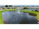 Scenic community pond with a fountain surrounded by lush green lawns and homes at 5905 Silver Sage Way, Sarasota, FL 34232