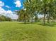 Beautiful backyard with lake view, lush lawn, and mature palm trees at 601 136Th St E Ct, Bradenton, FL 34212