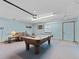 Bright game room features a pool table, comfortable seating, and carpet flooring at 601 136Th St E Ct, Bradenton, FL 34212
