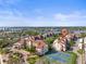 Aerial view of condo community with a tennis court, mature trees, and waterfront scenery at 6265 Midnight Pass Rd # 205, Sarasota, FL 34242