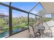 Screened balcony features a table and chairs overlooking a green space and waterway at this condo complex at 6265 Midnight Pass Rd # 205, Sarasota, FL 34242