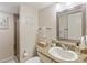 Cozy bathroom with granite vanity, framed mirror, shower, and beach-themed artwork at 6265 Midnight Pass Rd # 205, Sarasota, FL 34242