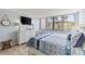Light and airy bedroom with a queen sized bed, dresser, television, and a large window with blinds at 6265 Midnight Pass Rd # 205, Sarasota, FL 34242