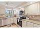 The spacious kitchen has granite countertops, a tiled backsplash, stainless steel appliances, and tile floors at 6265 Midnight Pass Rd # 205, Sarasota, FL 34242