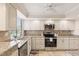 Renovated kitchen features granite countertops, tiled backsplash, stainless steel appliances and tile floors at 6265 Midnight Pass Rd # 205, Sarasota, FL 34242