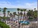 Inviting outdoor pool area with palm trees, lounge chairs, and ocean view at 6265 Midnight Pass Rd # 205, Sarasota, FL 34242