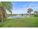 Scenic view of the backyard overlooking a tranquil lake, showcasing lush greenery at 6266 Buckingham St, Sarasota, FL 34238